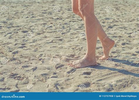 Chiuda Su Delle Gambe Della Donna Che Camminano A Piedi Nudi Sulla Sabbia Nelle Vacanze Estive