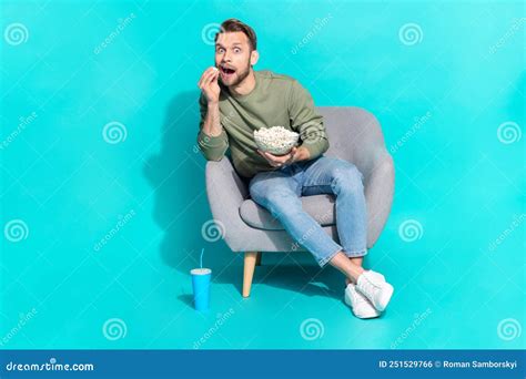 Full Size Photo Of Young Blond Guy Watch Tv Eat Wear Sweater Jeans