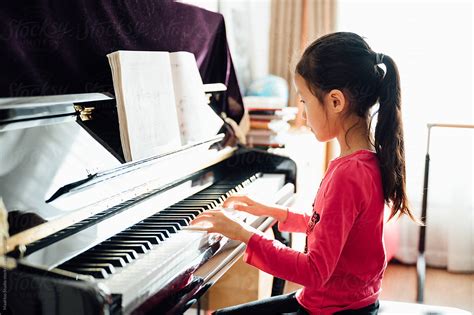 Portrait Of Cute Girl Playing Piano By Stocksy Contributor Maahoo