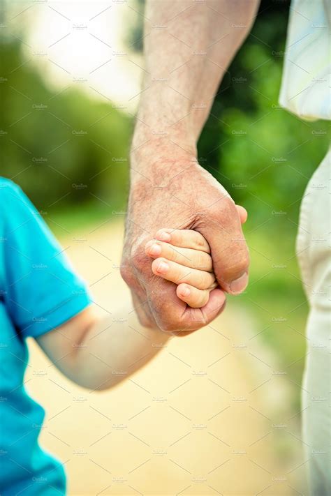 Child And Senior Man Holding Hands Stock Photo Containing Child And