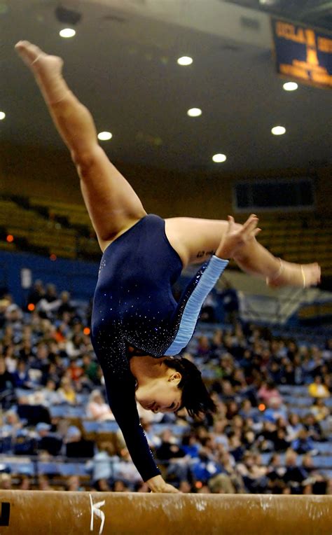 College Gymnast With One Hand On The Balance Beam Collegiate