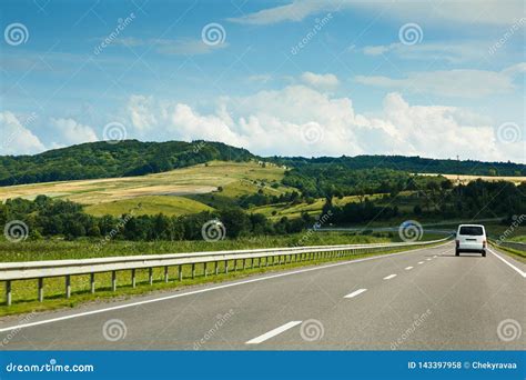 The Empty Asphalt Road And Blue Sky With White Clouds On The Sunny Day