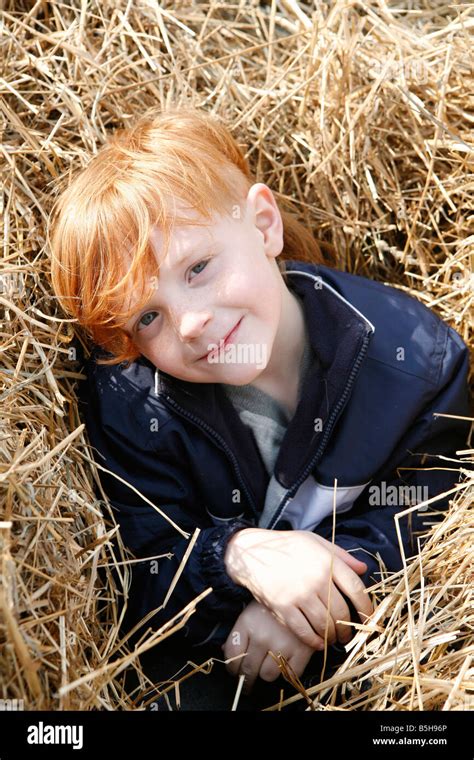 Cute Little Red Haired Boy Playing In The Hay Stock Photo