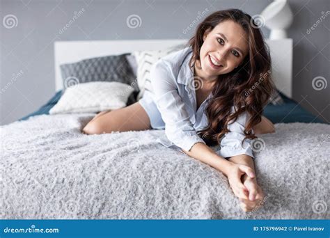 Portrait Of Beautiful Young Brunette Woman With Attractive Smile In Bed