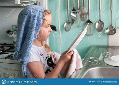 Pretty Young Girl Inspecting Dishes While Drying Up At The Kitchen Sink Stock Image Image Of