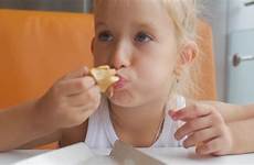eating girl little pizza food restaurant indoors smiling fast camera piece funny last