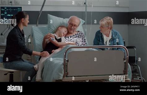 Niece Hugging Ill Grandpa At Visit In Hospital Ward Bed Stock Video