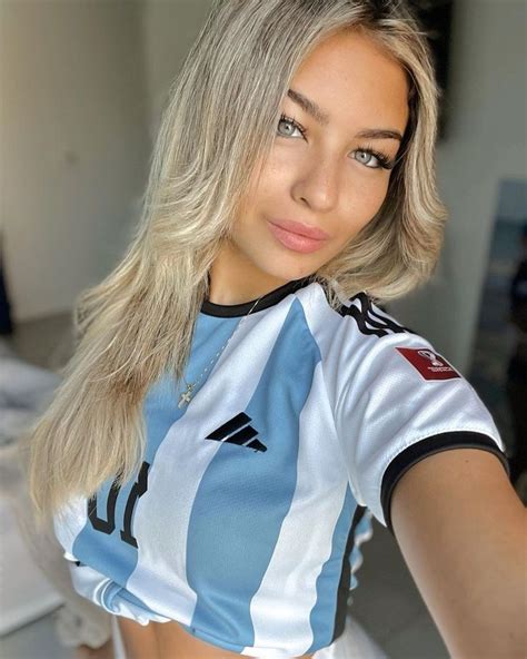 A Woman With Blonde Hair Wearing A Blue And White Soccer Jersey Looking