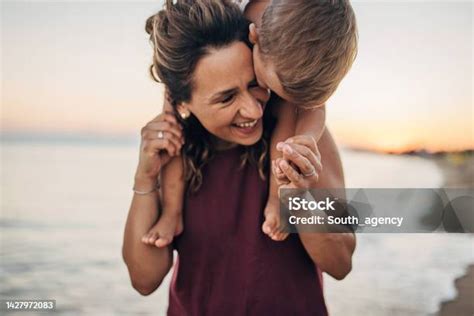 Una Madre Cargando A Su Hijo En La Playa Sobre Sus Hombros Foto De Stock Y Más Banco De Imágenes