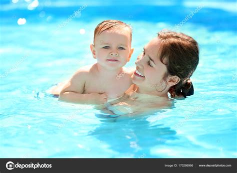 儿童游泳课。可爱的小男孩，学习与母亲在游泳池里游泳 — 图库照片©belchonock＃170286966