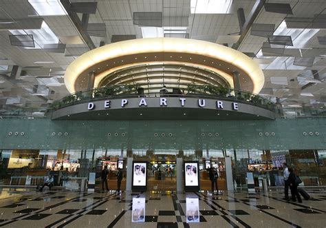 Singapore sin airport terminal 1. Passengers walk towards their departure gates in the newly ...