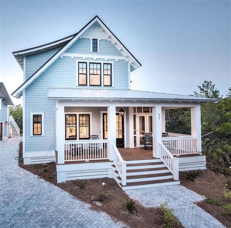 A Blue House With Stairs Leading To The Front Door And Covered Porchs