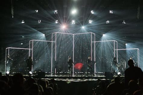 A Group Of People Standing On Top Of A Stage