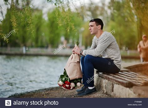 Buy your girlfriend flowers for a great suprise. Man with a bouquet of flowers waiting for his girlfriend ...