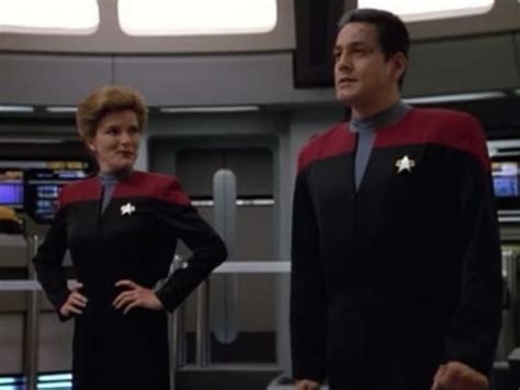 Two Men In Star Trek Uniforms Standing Next To Each Other