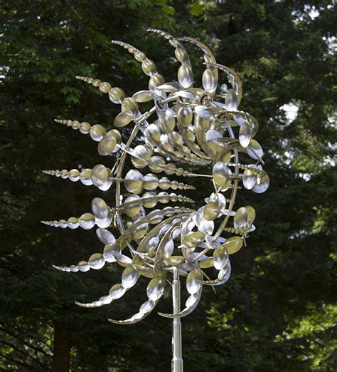 A Metal Sculpture With Lots Of Leaves On Its Sides And Trees In The