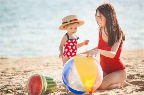 Joven Madre Bonita Y Su Pequeña Hija En La Playa Divirtiéndose Foto