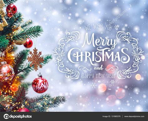 Xmas tree background and Christmas decorations with blurred, sparking, glowing and text Merry 