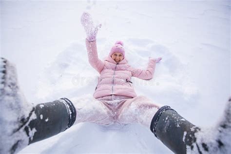 Happy Woman Lying On Snow And Moving Her Arms And Legs Smiling Woman Lying On Snow In Winter
