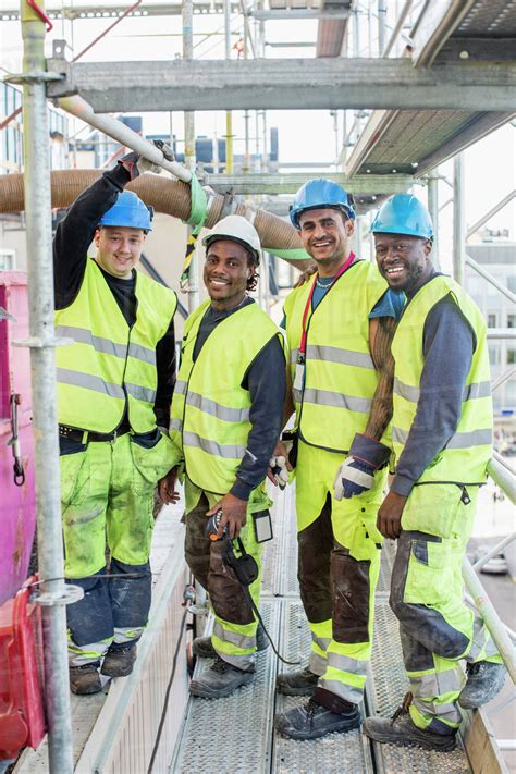 Full Length Portrait Of Construction Workers Standing Together At Site