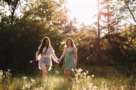 Happy Lesbian Couple Holding Hands While Walking In Forest In Summer Photograph By Cavan Images