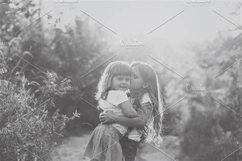two cute little sisters kiss high quality people images ~ creative market