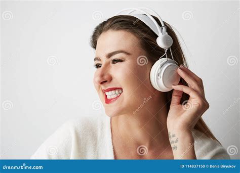 Smiling Beautiful Young Woman Listening To Music On Headphones Over
