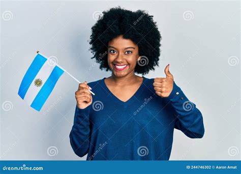 Young African American Woman Holding Argentina Flag Smiling Happy And