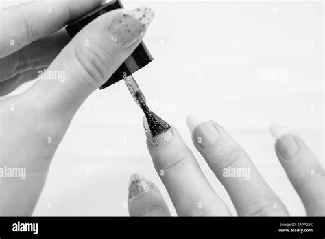 Female hands doing manicure, nail polish in gold glitter color on a