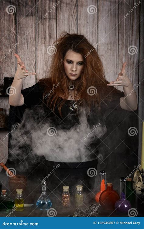 Witch Casting A Spell With Smoke And Cauldron Stock Image