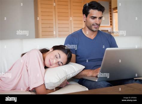 Hombre Con Un Portátil Mientras Su Novia Está Durmiendo Fotografía De
