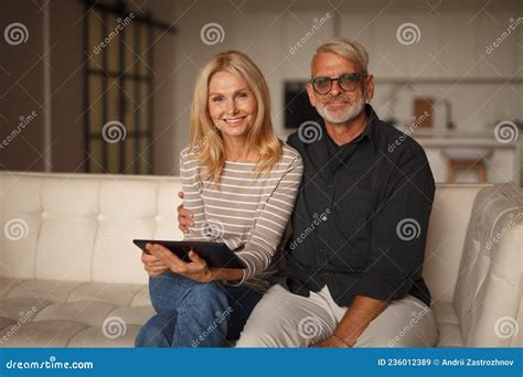 Portrait Of A Happy Mature Couple At Home On The Couch Together