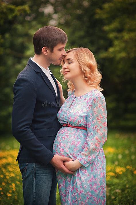 Image Of Beautiful Pregnant Woman And Her Handsome Husband Hugging The