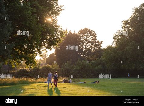 Young People Walking At Dusk In A London Park Stock Photo Alamy