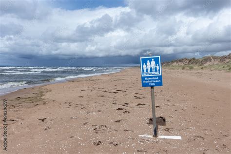 Nudist Beach Sign With The Inscription Nakenbad Nudist Beach FKK On A Beach In A Cloudy