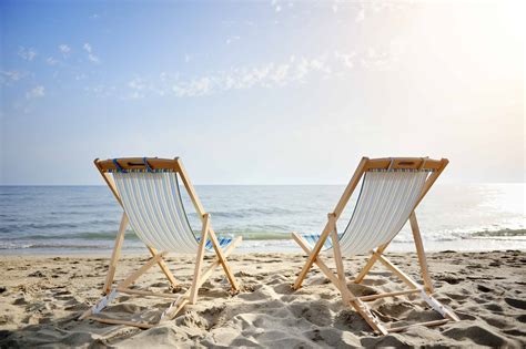 Couple Of Chairs On Sandy Beach At Sunset Relaxation Concept