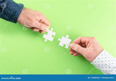 Hands Of Two Businessmen Connecting Matching Jigsaw Puzzle Pieces
