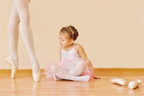 Premium Photo Little Girl In Ballet School Looking On The Legs Of
