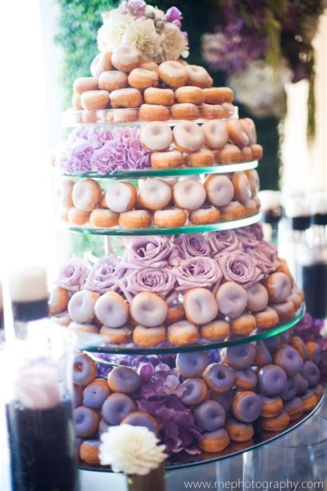 A Triple Layer Cake Made Out Of Doughnuts And Flowers