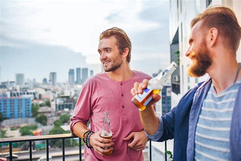 Men Drinking Beer On A Balcony Del Colaborador De Stocksy Lumina