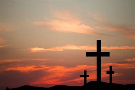 Three Wooden Crosses In Silhouette Stand Silently On A Hill At Cross