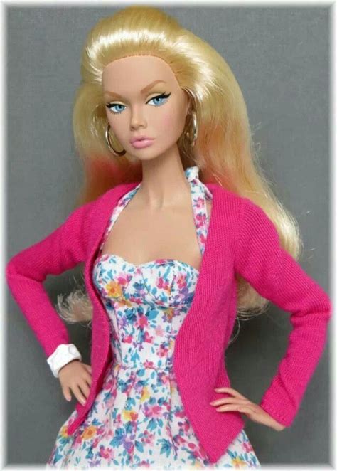 A Barbie Doll Wearing A Pink Cardigan And Floral Dress