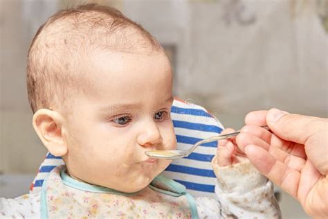 Cute Adorable Baby Eating Porridge With A Spoonful Of The Concept Of
