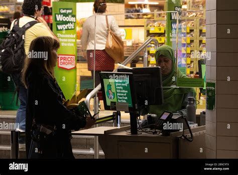 sydney australia 24 mar 2020 a supermarket worker at woolworths is seen behind a new