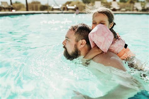 Father And Daughter Swimming Together In A Pool On California Vacation