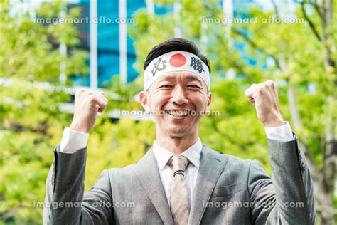 「必勝」のハチマキを頭に巻くスーツ姿の男性の写真素材 [202039903] イメージマート