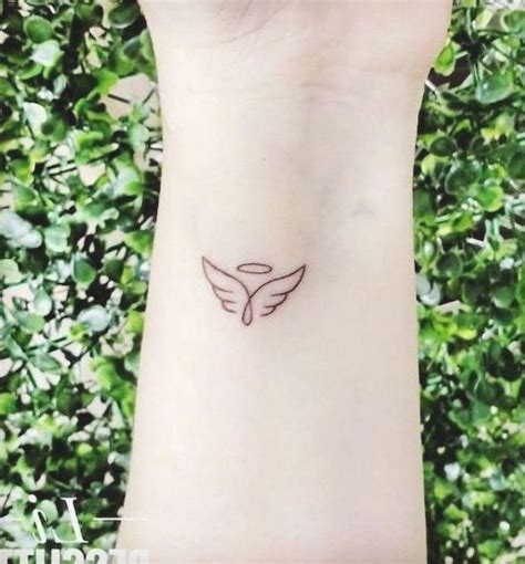 Small Angel Wings Tattoo Wrist Tattoo Green Bushes In The Background