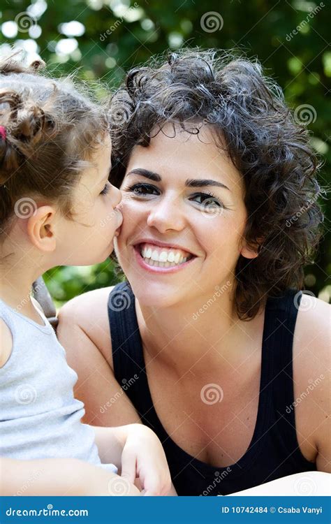 Hija Que Besa A Su Madre Sonriente Foto De Archivo Imagen De Verde