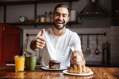 Portrait Of Joyful Man 30s Eating While Having Breakfast In Stylish
