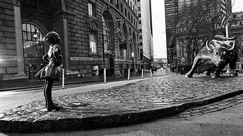 for international women s day bronze statue of girl placed directly in front of wall street